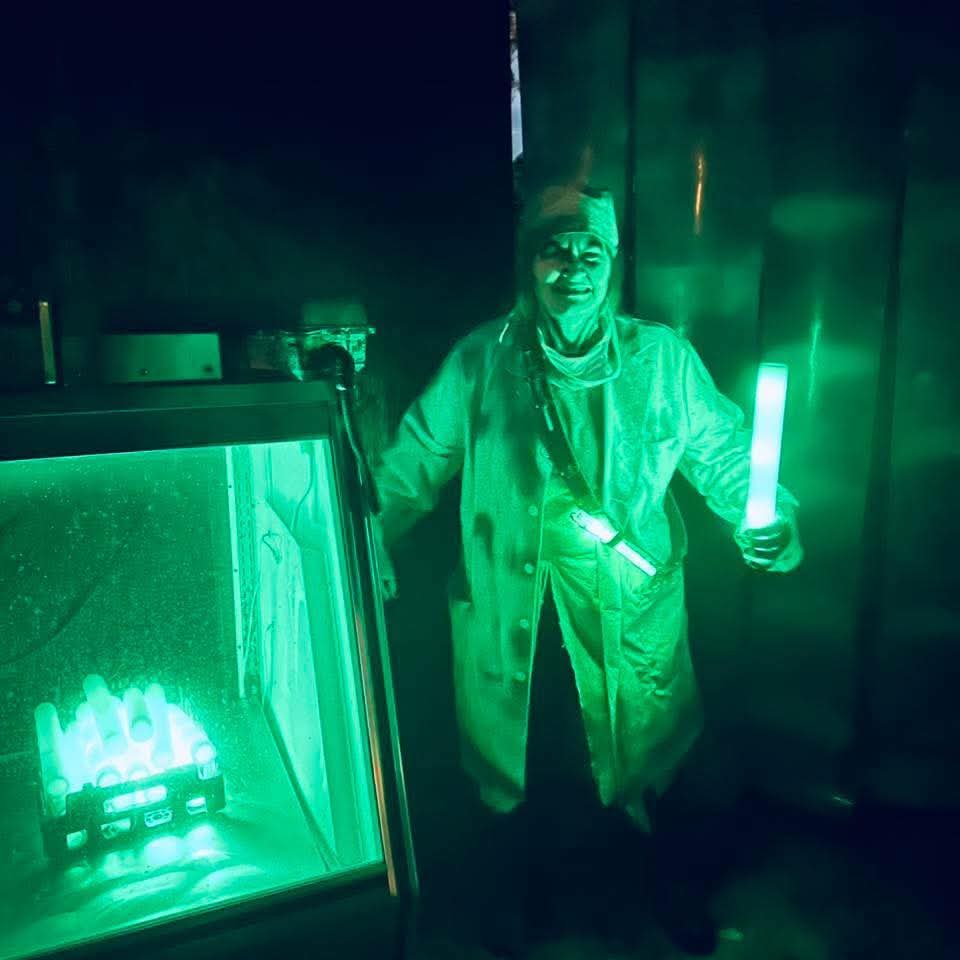 Wooden walkway leading into a haunted attraction at night